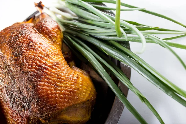 オーブンで焼き鴨 閉じます 新鮮なタマネギと黄金の皮を持つローストガチョウ 白い背景に — ストック写真