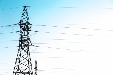 Açık mavi gökyüzüne karşı kablolarla elektrik desteği. Elektrik destek servisi.