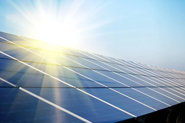 阳光照射在发电厂的太阳能电池板上 日落时的太阳能清洗机站 图库图片