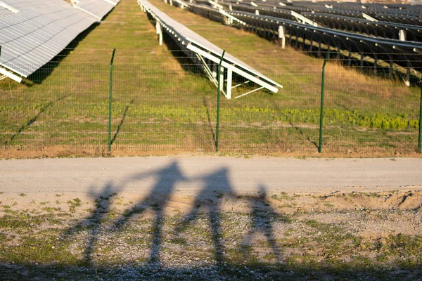 Schatten Der Wandernden Familie Der Nähe Der Solarstation Menschen Halten lizenzfreie Stockbilder