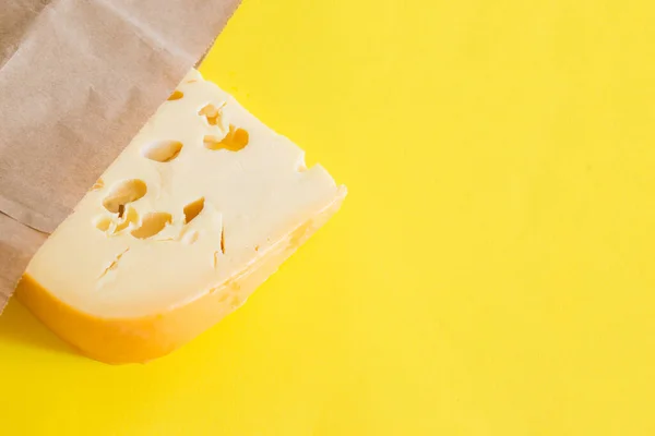Maasdammer Kaas Inpakpapier Met Kopieerruimte Een Gele Achtergrond — Stockfoto