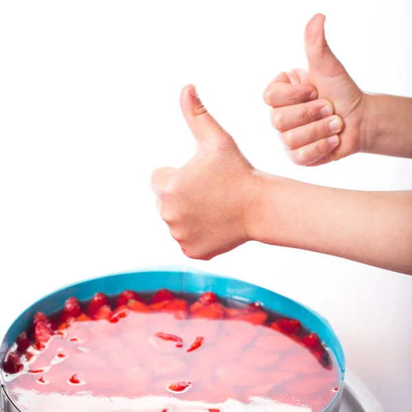 Çocuk Elleri Beyaz Arka Planda Çilekli Cheesecake Için Baş Parmağını — Stok fotoğraf