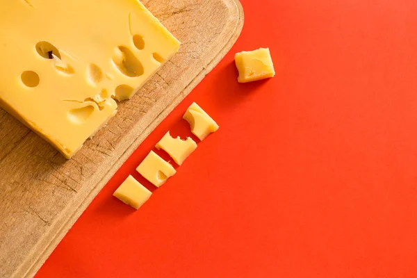 Plakjes Kaas Voor Gesneden Snacks Een Bord Een Rode Achtergrond — Stockfoto