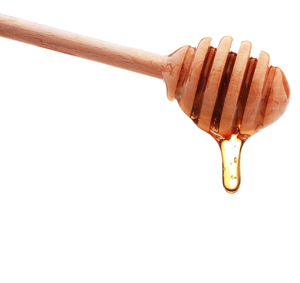 Honey dripping from wooden dipper — Stock Photo, Image