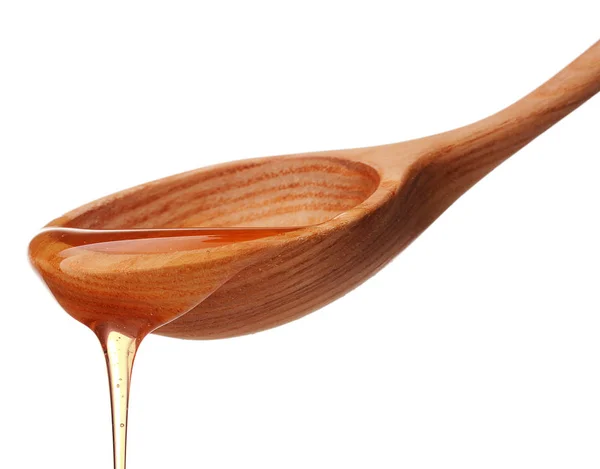 Honey dripping from a wooden honey — Stock Photo, Image