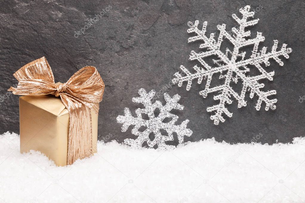 Christmas greeting card with gold gift box on snow