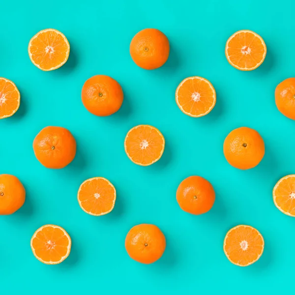 Fruit pattern of fresh mandarin slices on blue background. Flat