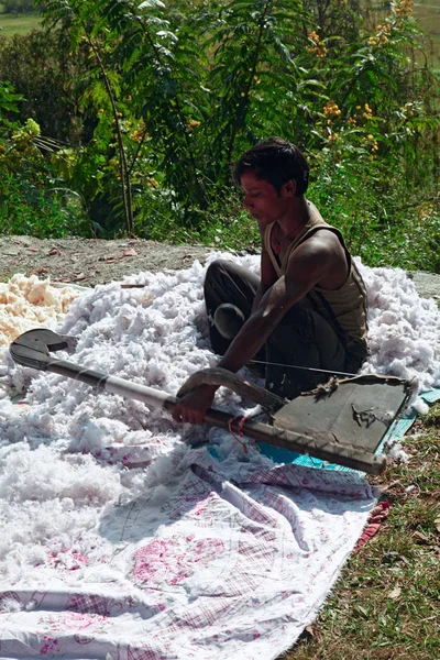 Nepalês homem puffs up travesseiro para baixo — Fotografia de Stock