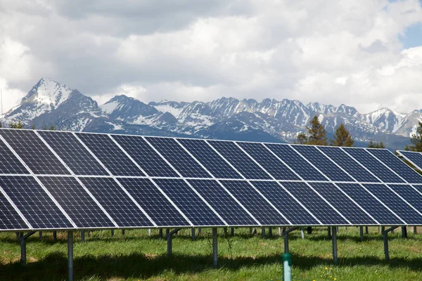 太阳能电池板与雪山背景 免版税图库图片