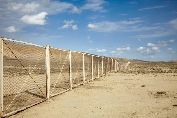 Clôture dans le désert azerbaïdjanais entourant le parc national du Gobustan — Photo