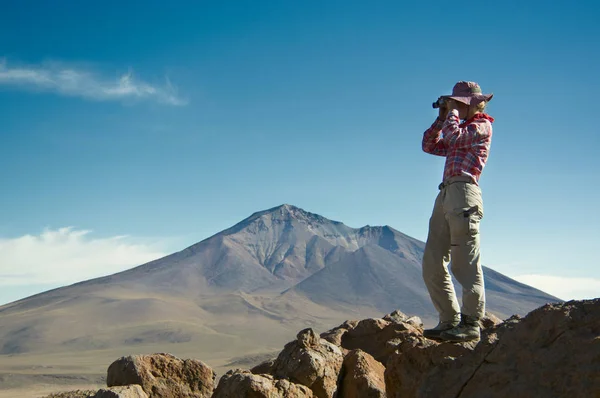 Young female traveller is using binoculars in the mountains — Stock Photo, Image