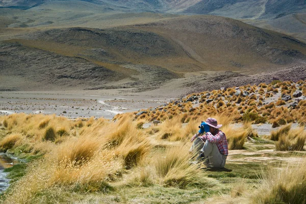 Молода жінка мандрівник використовує бінокль, щоб побачити віддалені об'єкти — стокове фото