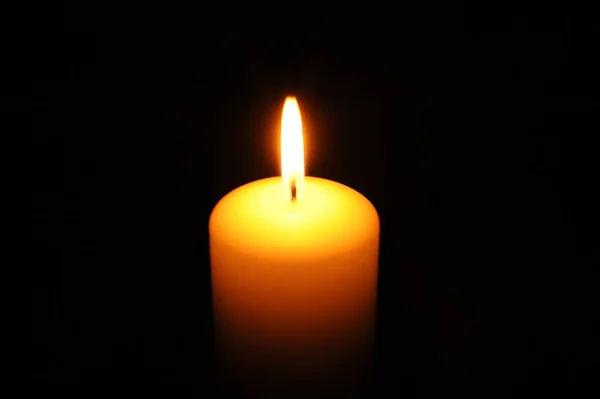 Палаюча свічка на чорному фоні — стокове фото