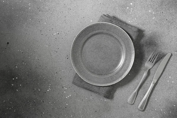 Серую Тарелку Ножом Вилкой Сером Столе Рядом Тарелкой Кухонное Полотенце — стоковое фото