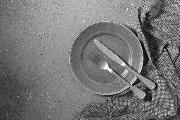 Серую Тарелку Ножом Вилкой Сером Столе Рядом Тарелкой Кухонное Полотенце — стоковое фото