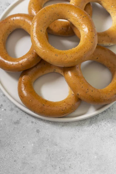 Bagels Met Maanzaad Een Witte Keramische Plaat Een Grijze Keukentafel — Stockfoto