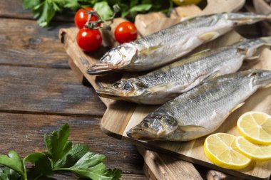 Kahverengi ahşap bir masanın üzerinde tütsülenmiş ya da kurutulmuş eritilmiş balık. Metin için boşluk olan üst görünüm