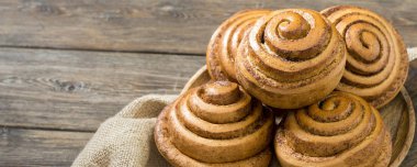 Tahta bir masada, tahta bir tabakta çörekler. Kapatın. Site için pankart