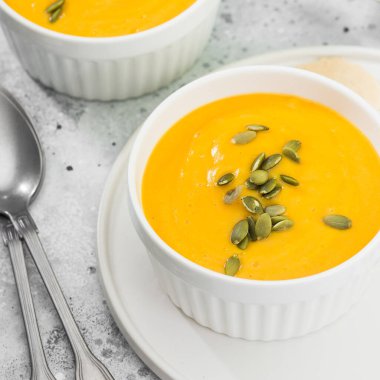 Çekirdekli kremalı kabak kremalı çorba. Sonbahar yemeği. Açık gri arkaplan