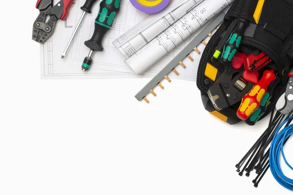 Kurucunun inşaat aletleri beyaz arka planda siyah bir çantada. Elektrikçi aletleri ve projesi. Metin alanının bir kopyasıyla üstteki görünüm. Yatay yönelim