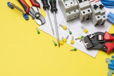 Sarı arka planda kripto aletleri, elektrikli güvenlik makineleri ve elektrikli aletler. Elektrikçi aletleri