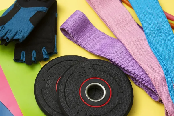 Expanders and elastic bands for fitness with different degrees of load on a yellow background. Elastic bands for fitness. Sports equipment for sports activities