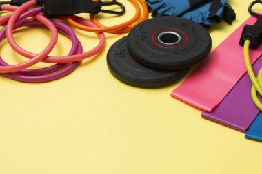Genişleticiler ve elastik bantlar, sarı arka planda farklı derecelerde yükleme için. Spor için elastik bantlar. Spor faaliyetleri için spor ekipmanları