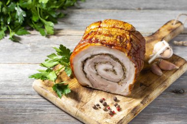 Gri ahşap bir masada, tahta bir tahtanın üzerinde sebzeli ve otlu rulo köfte. Pişmiş et. Metin için boşluk olan üst görünüm. Dikey oryantasyon. Kırsal biçim