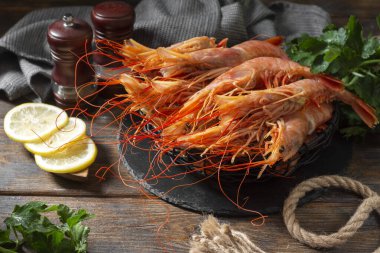 Kahverengi ahşap bir masada siyah metal bir sepetin içinde büyük Langoustines. Sağlıklı beslenme için deniz ürünleri