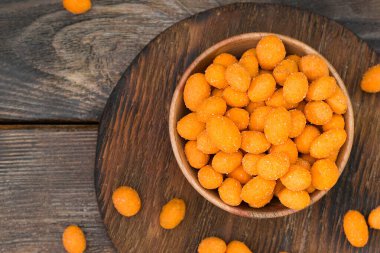 Kahverengi ahşap bir masada ahşap bir kasede acı biber soslu fıstıklar. Kırsal tarzda. Yukarıdan görünüşü