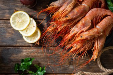 Kahverengi ahşap bir masada siyah metal bir sepetin içinde büyük Langoustines. Sağlıklı beslenme için deniz ürünleri