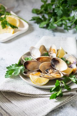 Açık gri bir masada seramik tabakta istiridye pişirdim. Deniz ürünleri yemeği.