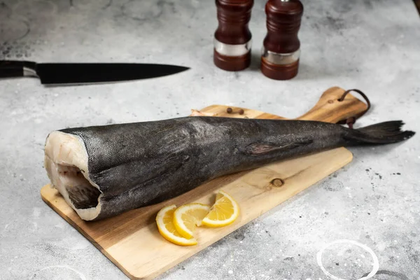 Merluzzo Nero Una Tavola Legno Sul Tavolo Cucina Grigio Chiaro — Foto Stock