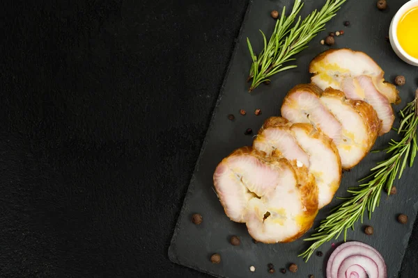 Smoked Sevryuga or sturgeon on a black slate Board on a black table. Smoked fish Sevryuga. Fish slicing. Top view with space for text