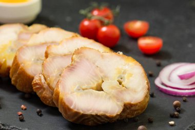 Siyah bir masada siyah bir tahtada Sevryuga ya da mersin balığı tüttürdüm. Tütsülenmiş balık Sevryuga. Balık doğrama