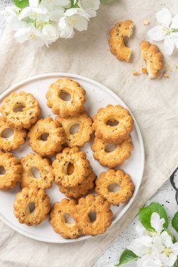 Işık masasında büyük beyaz bir seramik tabakta çörekler. Tabakta bir sürü kurabiye var. Ev yapımı lezzetli hamur işleri. Metin için boşluk olan üst görünüm