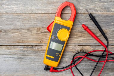 Gri ahşap bir masada elektrikli testçi. Elektrikçinin aleti masanın üzerinde. Elektrikli aletler. Metin için boşluk olan üst görünüm