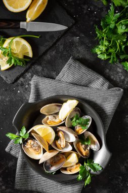 Siyah mutfak masasında siyah seramik tabakta istiridye pişirdim. Deniz ürünleri tabağı. Yukarıdan görünüşü