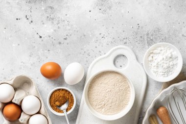 Mutfak zemininde pişirmek için gerekli malzemeler. Yumurta, un, tarçın, şeker, mutfak masasında soda. Pişirme hazırlığı kavramı. Metin için boşluk olan üst görünüm