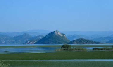 Resimli dağ manzarası, ön planda bir göl.