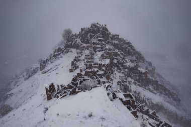 Sisli kış Kafkasya dağlarında terk edilmiş Gamsutl şehrinin hava manzarası, Dağıstan, Rusya