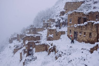 Eski antik terk edilmiş şehir Gamsutl sisli, karlı, Kafkasya dağlarında, Dağıstan, Rusya