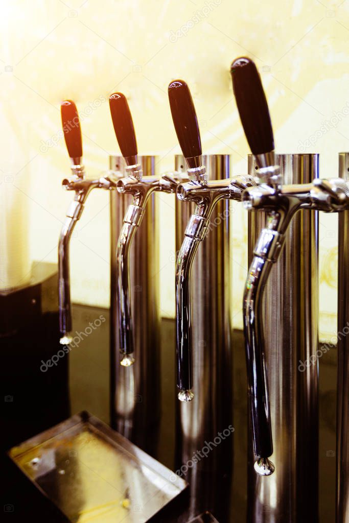 Beer taps in a row in the pub, selective focus