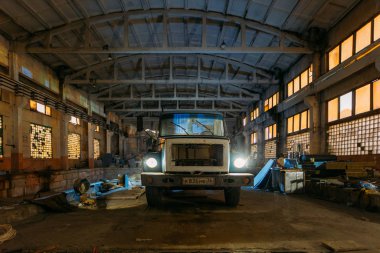 Terk edilmiş fabrika deposunda eski paslı bir kamyon.