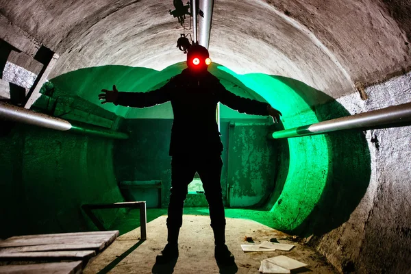 Creepy silhouette of man in mask with shining eyes in dark abandoned bunker. Horror about maniac concept — Stock Photo, Image