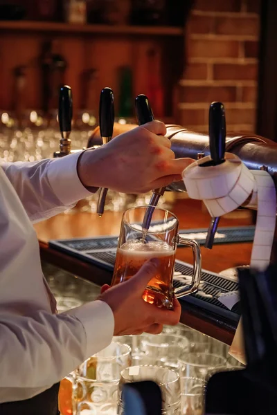 Barman verser de la bière pression de la grue dans le verre dans le pub — Photo