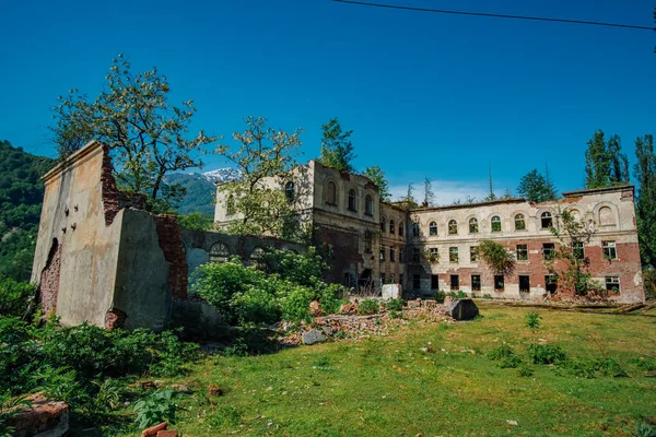 Escuela arrasada en la ciudad minera fantasma Akarmara, consecuencias de la guerra en Abjasia, concepto verde post-apocalíptico — Foto de Stock