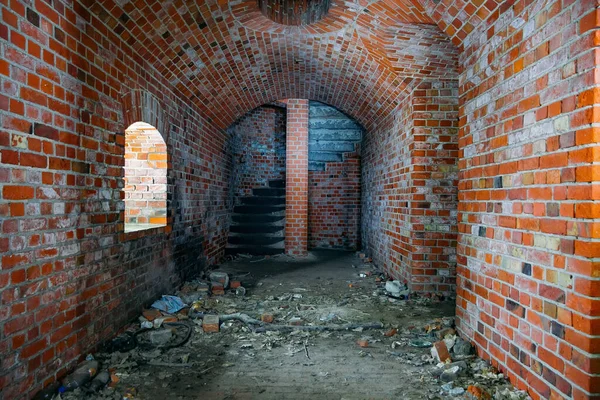 Couloir voûté de la vieille forteresse prussienne de briques rouges, se terminant par un escalier en colimaçon — Photo