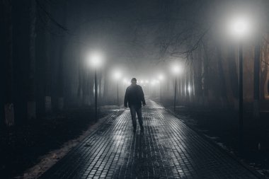 Sisli parkta sokakta yalnız başına yürüyen üzgün bir adam. ön görünüm