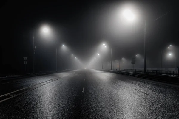 Foggy route brumeuse de nuit éclairée par des lampadaires — Photo